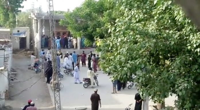 People gather outside a Hindu temple that was set on fire by an angry mob after reports that a Hindu boy had urinated in the library of an Islamic seminary, in Bhong