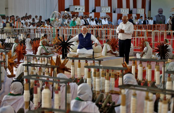 ndia's Prime Minister Narendra Modi spins cotton on a wheel, in Ahmedabad