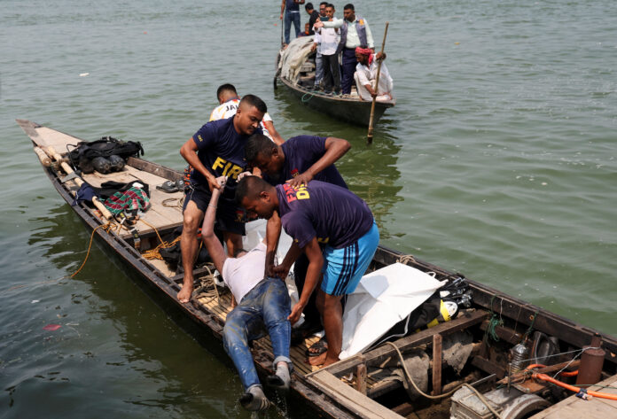 Rescue personnel retrieve the body of a man after a bus plunged into Padma River while attempting to board a ferry in Rajbari